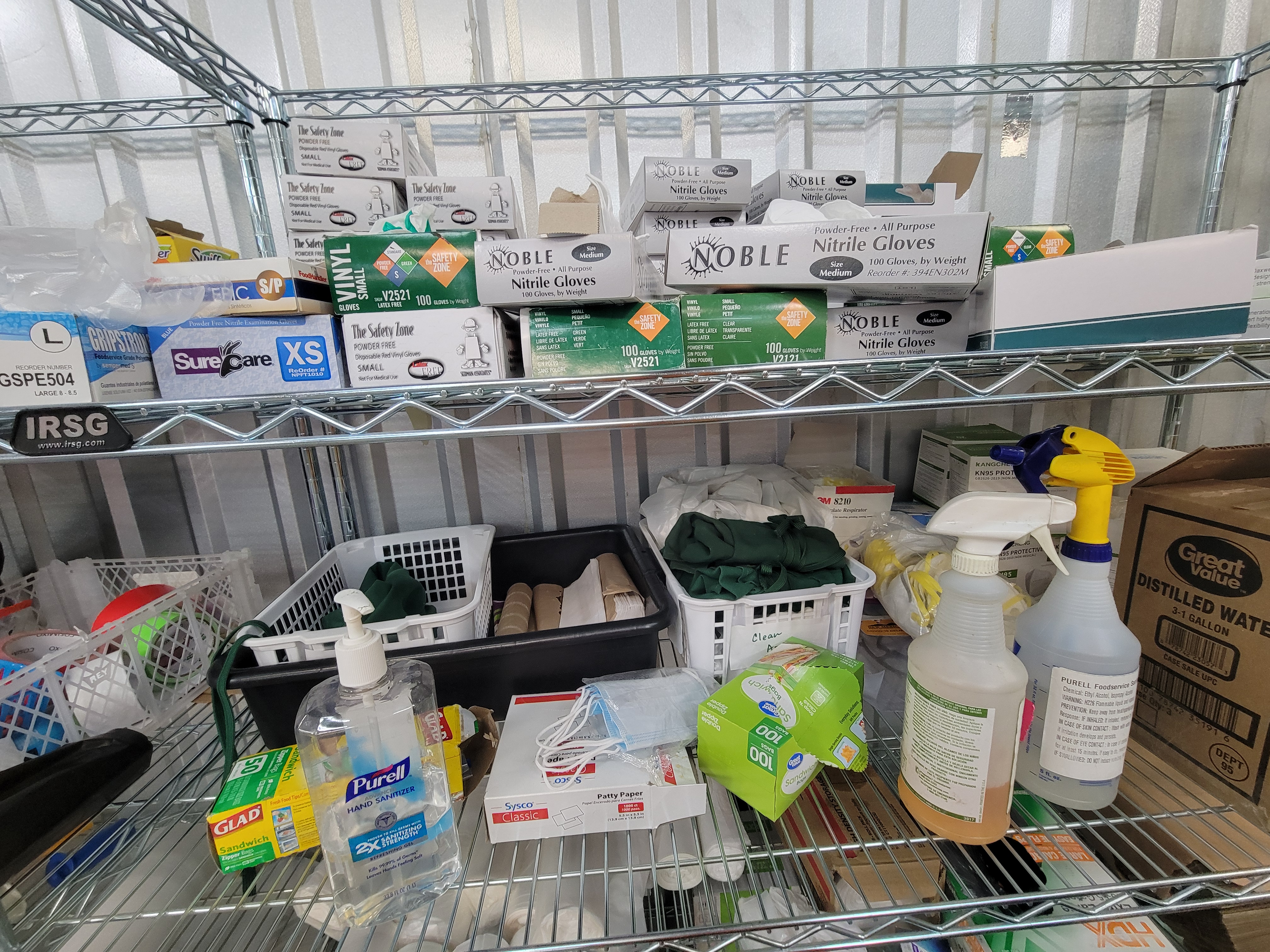 Cleaning supplies and gloves on a shelf.